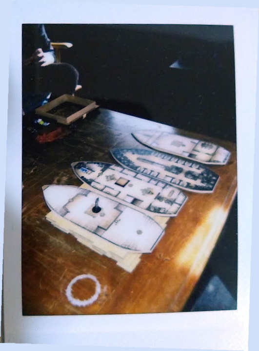 A board game table set up with an image of four boats seen from the top.