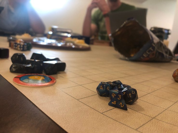 A stack of role-playing-game dice, dark blue. The dice are stacked on a gridlike board.